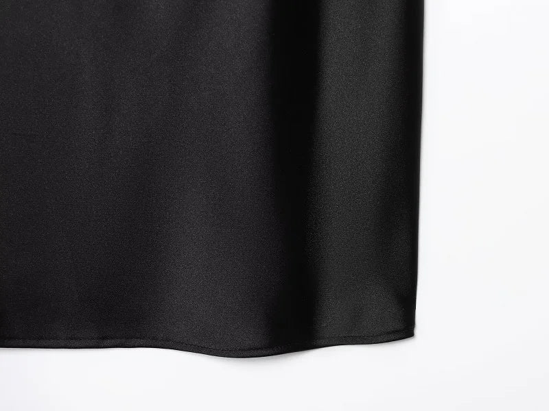 Saint Claire Noir Satin Backless Camisole displayed on a model, featuring smooth satin fabric and a sleek backless design.