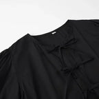 SAINT CLAIRE Aurélie Ruffle Blouse in soft fabric with ruffled details and long sleeves, displayed on a hanger.