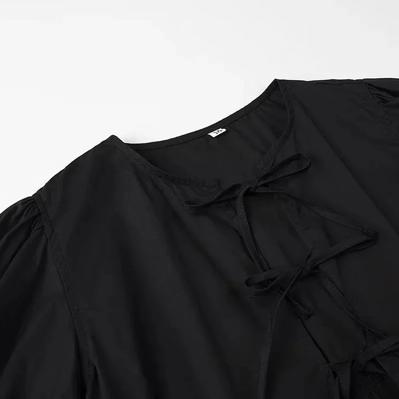 SAINT CLAIRE Aurélie Ruffle Blouse in soft fabric with ruffled details and long sleeves, displayed on a hanger.
