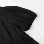 SAINT CLAIRE Aurélie Ruffle Blouse featuring feminine ruffles and lightweight fabric, displayed on a hanger against a neutral background.