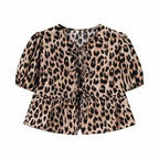 SAINT CLAIRE Aurélie Ruffle Blouse with feminine ruffle details and lightweight fabric, displayed on a hanger.